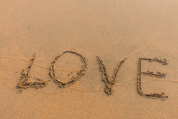 The word love written on the sand.