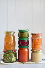 Variety of preserved food in glass jars - pickles, jam, marmalade, sauces, ketchup. Preserving vegetables and fruits. Fermented food. Autumn canning. Conservation of harvest.