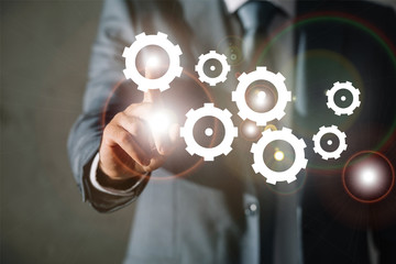 cropped view of businessman in suit touching gears with finger