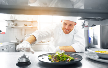 food cooking, profession and people concept - happy male chef cook with plate of soup and salad ringing bell at restaurant kitchen table