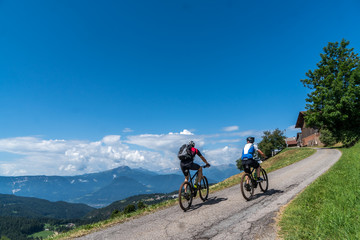 Fototapeta na wymiar Mountainbiker aufwärte mit Bergkulisse
