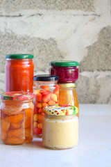 Variety of preserved food in glass jars - pickles, jam, marmalade, sauces, ketchup. Preserving vegetables and fruits. Fermented food. Autumn canning. Conservation of harvest.