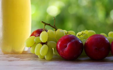 green grapes and sweet ripe plums on table