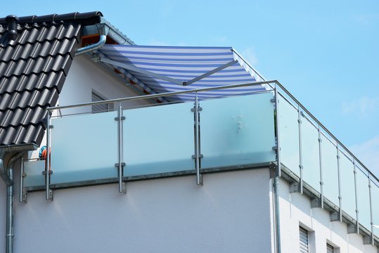 Verglaster Metall-Balkon am Dachgeschoss eines Wohnhauses