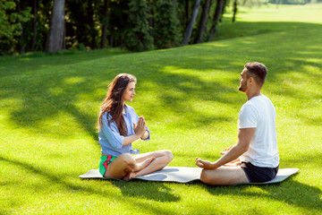 girl in park doing yoga with their teacher