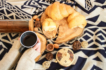 Warm flat lay composition with cup of tea,croissants and hands.