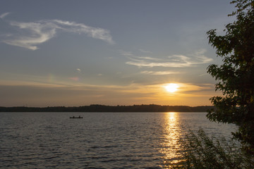 Fototapeta na wymiar Friends Rowing on a Sunset Lake