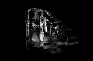 Four ice cubes isolated on the deep black background