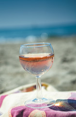 Beach party with sea view, romantic celebration on sunny sandy beach, one glass with rose wine