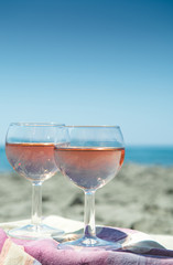 Beach party with sea view, romantic celebration on sunny sandy beach, two glasses with rose wine
