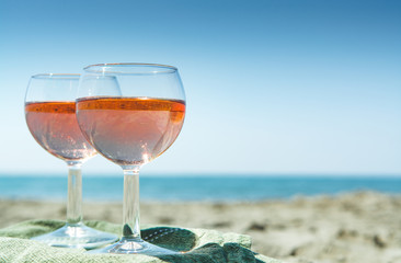 Beach party with sea view, romantic celebration on sunny sandy beach, two glasses with rose wine