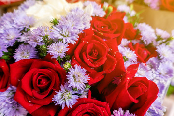 The roses with others white in the bouquet with the light in nature , selective focus.