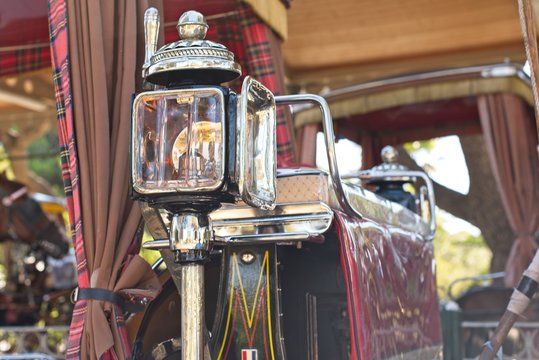 Close-up view of brass candle powered headlamp on a horse drawn carriage.