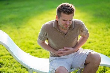 Caucasian man having terrible pain in stomach. Diarrhea or gastroenteritis health problem.