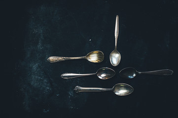 Antique silver tea spoons on black background