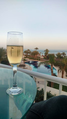 A glass of champagne at sunset with palm trees.