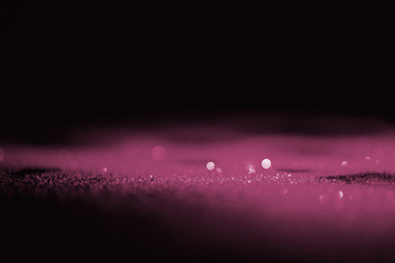 abstract shiny pink glitter on dark background with copy space