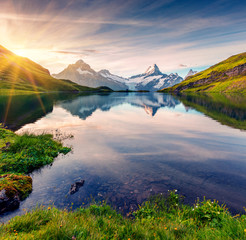 Colorful summer sunrise on Bachalpsee lake with Schreckhorn and Wetterhorn peaks on background.