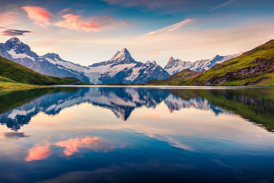 Colorful summer sunrise on Bachalpsee lake with Schreckhorn and Wetterhorn peaks on background.