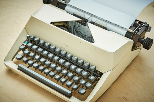 bright old typewriter with gray keys on a wooden table