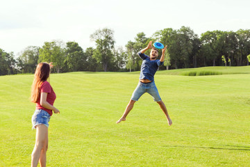 couple in love playing frisbee in the park, the concept of a healthy lifestyle.