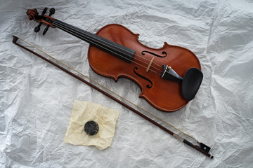 Fototapeta na wymiar The wooden violin put beside bow and rosin,on background,prepare for practice