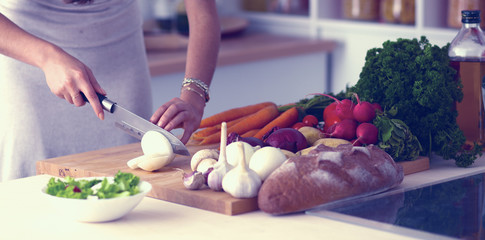 Young woman cutting vegetables in the kitchen