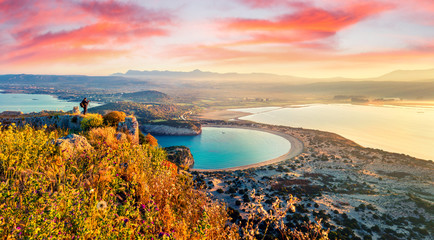 Photographer take a picture of spring view of the Voidokilia beach from Navarino Castle. Great sunrise on the Ionian Sea, Pylos town location, Peloponnese, Greece, Europe.