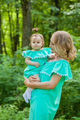 Young mother and daughter in identical dresses for a walk