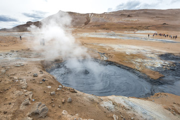 hverir geothermal area in iceland, active mud pod with steam and people in background