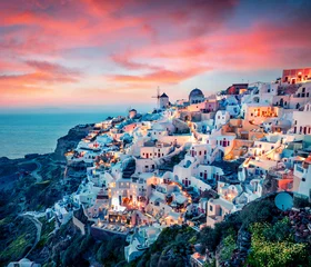Schilderijen op glas Impressive evening view of Santorini island. Picturesque spring sunset on the famous Greek resort Oia, Greece, Europe. Traveling concept background. Artistic style post processed photo. © Andrew Mayovskyy