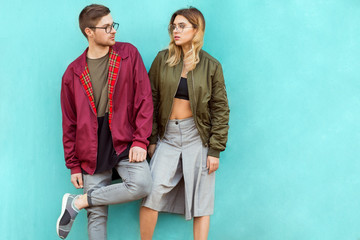 fashion couple standing posing near blue wall