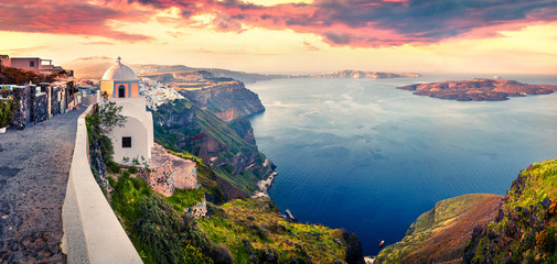 Obraz premium Sunny morning panorama of Santorini island. Picturesque spring sunrise on the famous Greek resort Thira, Greece, Europe. Traveling concept background. Artistic style post processed photo.