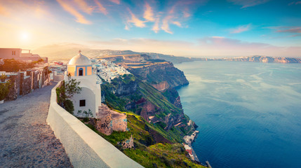 Sunny morning panorama of Santorini island. Picturesque spring sunrise on the famous Greek resort Thira, Greece, Europe. Traveling concept background. Artistic style post processed photo.