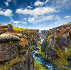 Unbelievable summer view of Fjadrargljufur canyon and river. Spectacular morning scene of the volcanic landscape in South east Iceland, Europe. Beauty of nature concept background.