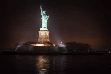 liberty statute in New York city at night, view from the new york water taxi