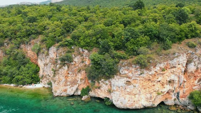 Aerial (drone) truck shot from right to left of Macedonian shore in Ohrid Lake, Pesztani and Trpejca.