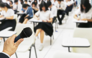 Education Background with copy space  shown teacher hold microphone in hid hand to lecture for his students in the classroom.