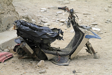 Completely wrecked scooter on a parking lot