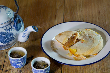 Chinese pastry in white dish with Chinese tea and teapot