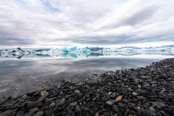 Jökulsárlón glacier lagoon with refelctions of a ice rock in the water an the glacier in the background of the jökulsarlon