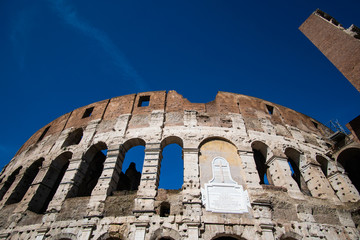 Detail of Roman Colosseum in Italy against blue sky