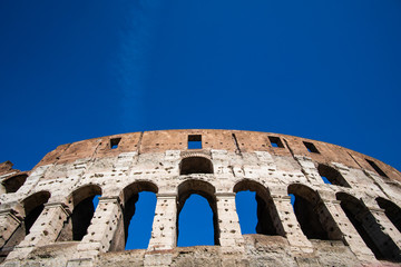 Detail of Roman Colosseum in Italy against blue sky