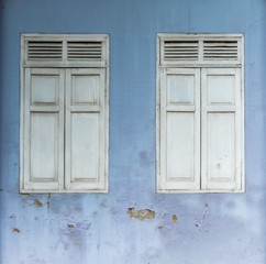 antique wooden window at blue abandoned concrete buildings.