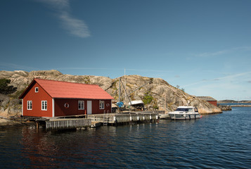 Naklejka premium Marine lodge of red color on the rocky coast of a Swedish island.