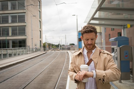 Man checking time on watch in platform