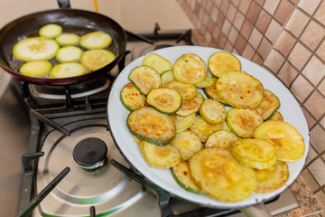 Roast zucchini in the frying pan in the kitchen