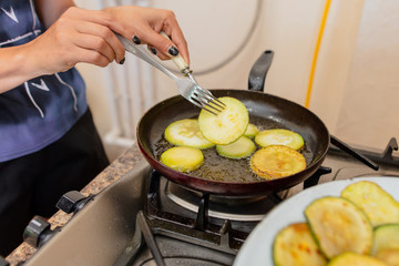 Roast zucchini in the frying pan in the kitchen