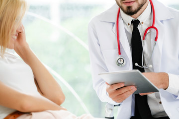 Male Doctor and Female Patient in Hospital Office