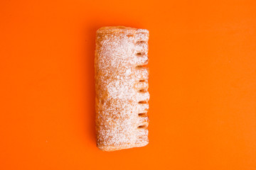 cream cane cake, with sugar on orange background